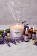 Lavender Serenity Candle on marble surface with lavender sprigs and aromatherapy oils